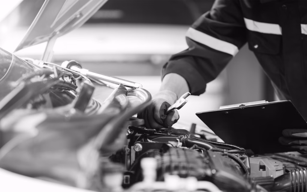 Mechanic Looking Under Hood Of Car